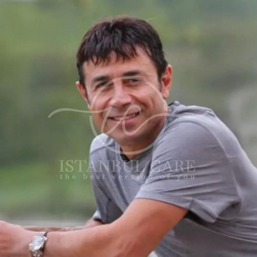 Foto dopo il trapianto di capelli presso Istanbul Care — uomo sorridente con capelli ricostruiti e maglietta grigia, fotografato all'aperto