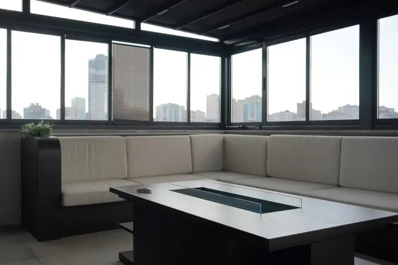 Corner sofa and table in the clinic lounge, with a row of windows looking out over the city skyline