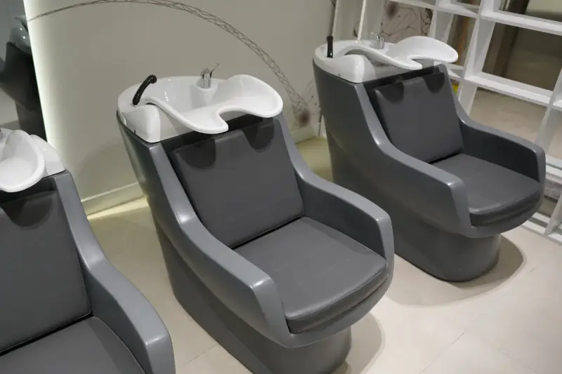 Hair washing units with grey seats and white basins in the clinic's hair washing area