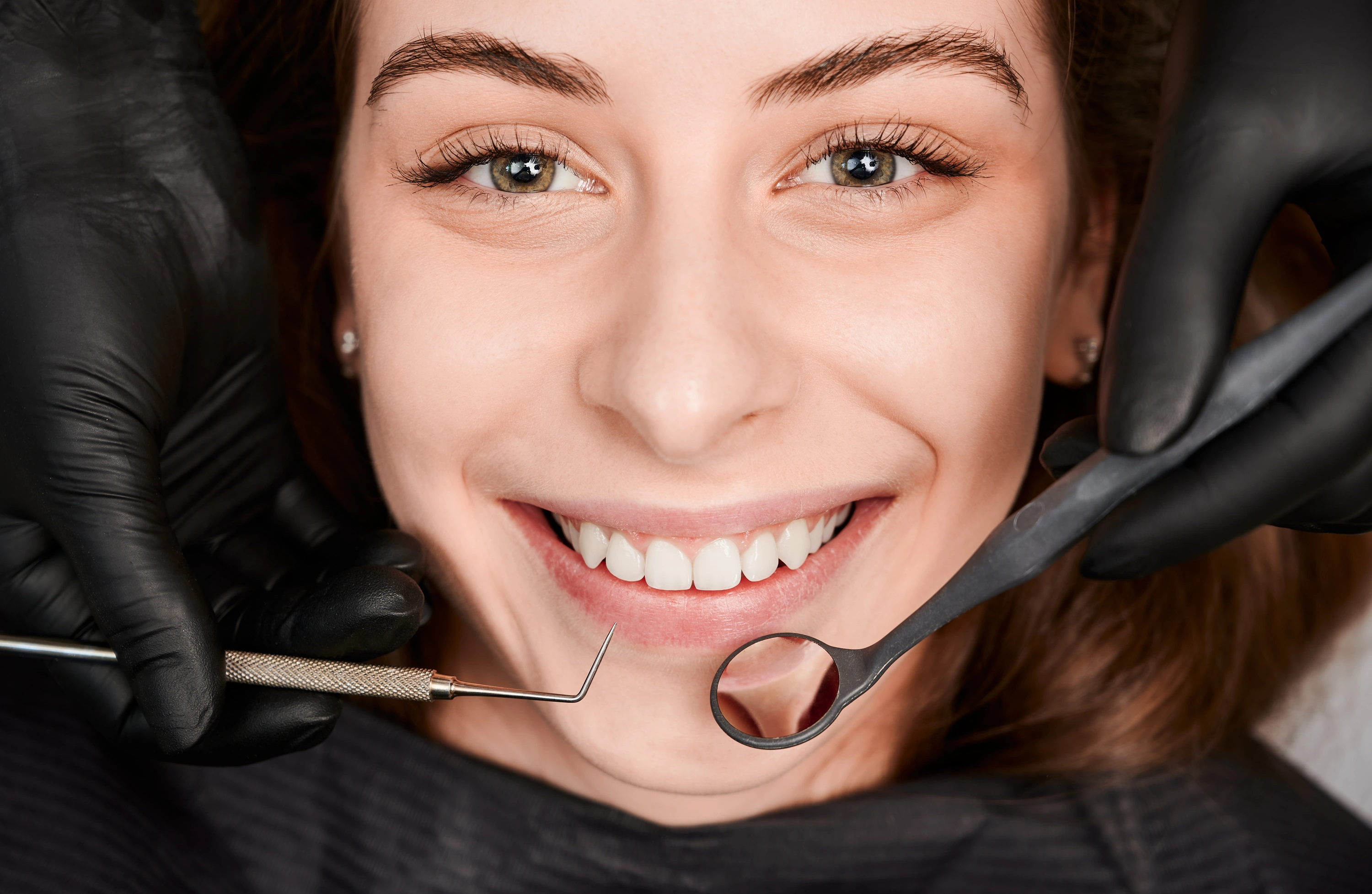 cheerful-young-woman-having-dental-examination-clinic