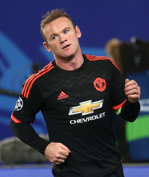 Wayne Rooney in a black Manchester United away kit during a match, photographed from below with his short hair pushed back off the forehead.